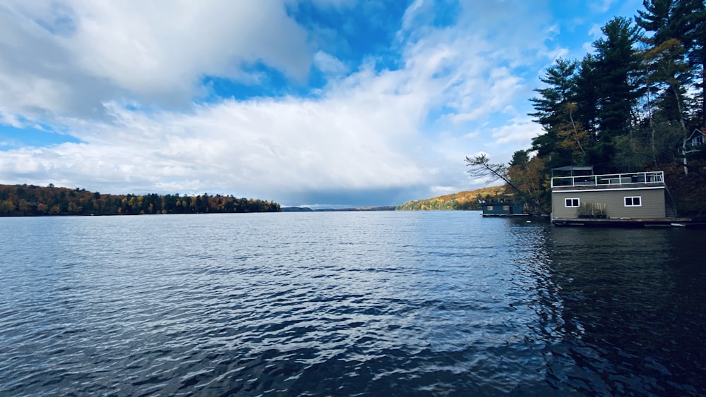 a houseboat on a lake surrounded by trees