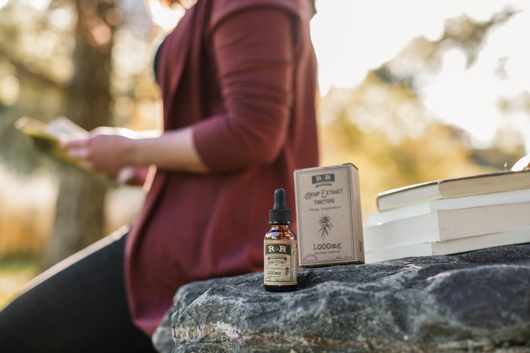 Colorado woman reading with hemp extract tincture in a fall and autumn setting.