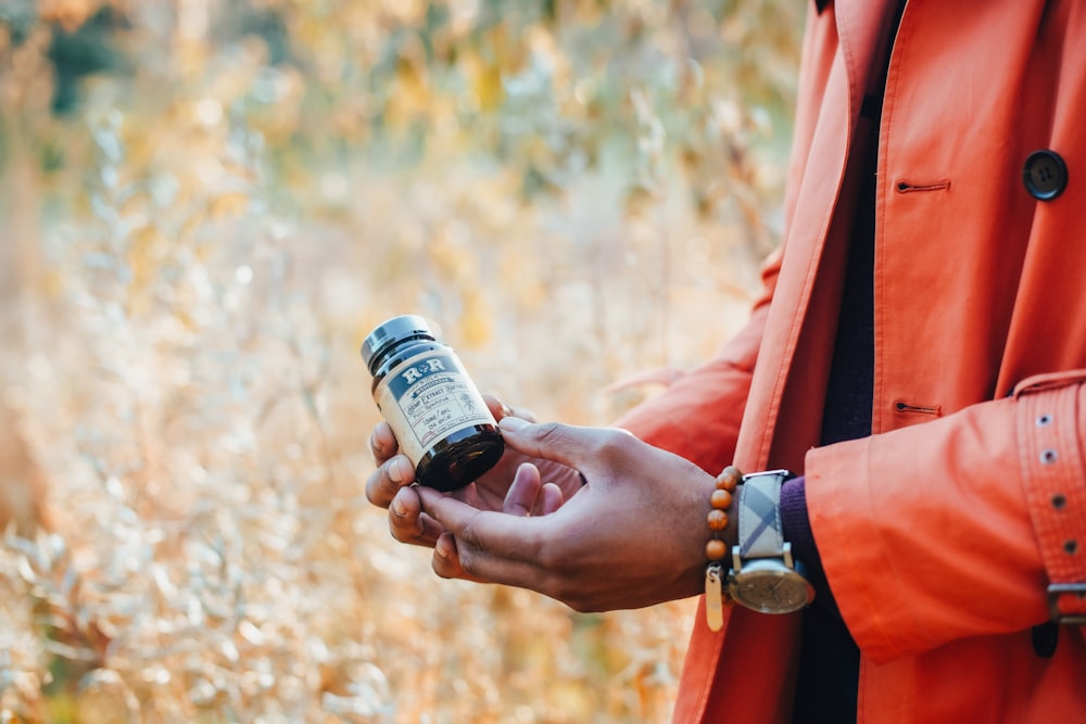 unknown person holding black bottle