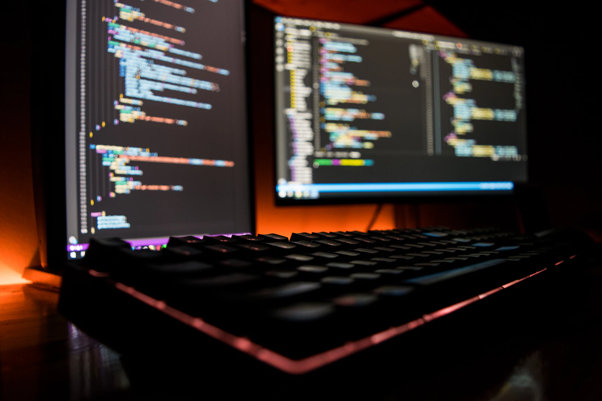 Screens displaying code in a darkened development studio