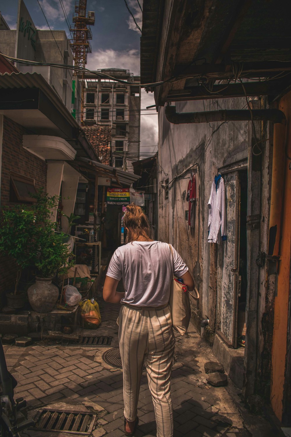 woman in white short-sleeved shirt walking near buildings