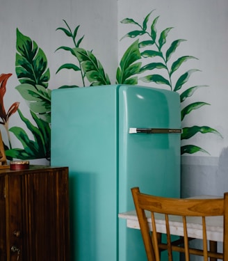 blue refrigerator beside green-leafed plant