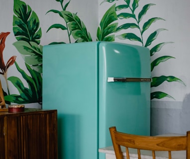 blue refrigerator beside green-leafed plant