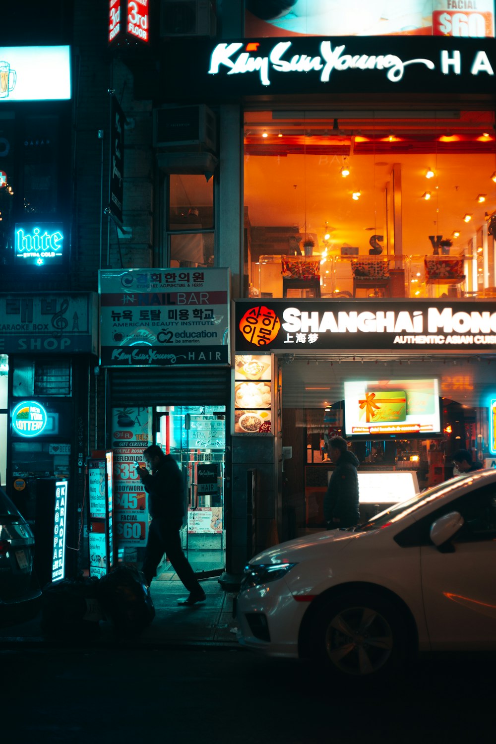 white car beside building during nighttime