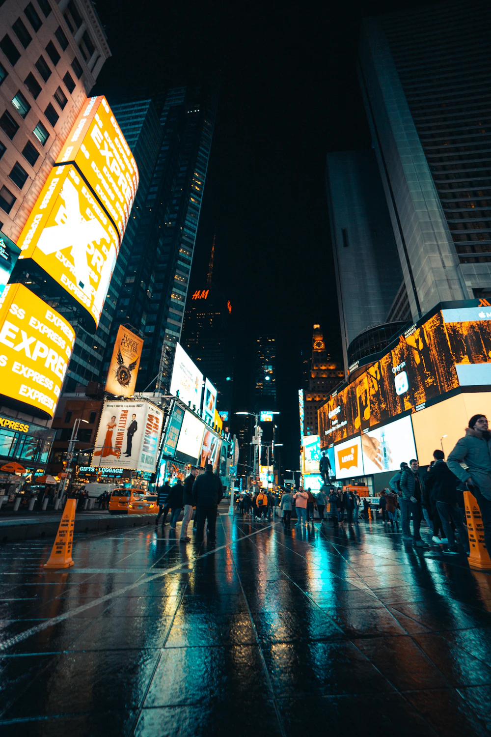 Bright digital billboards lighting up a city street at night