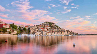 Panoramic view of Kotor's old town with its medieval walls and bay at sunset.