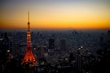 Outdoor tower lighting illuminating a cityscape at dusk.