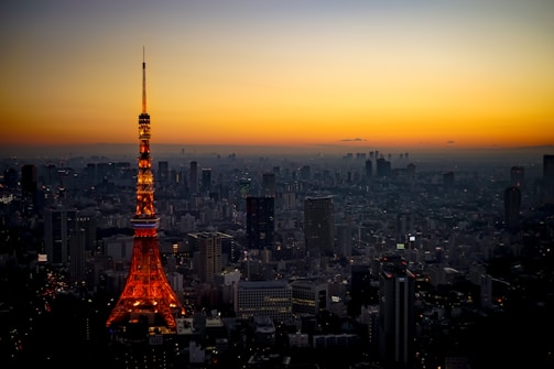 Outdoor tower lighting illuminating a cityscape at dusk.