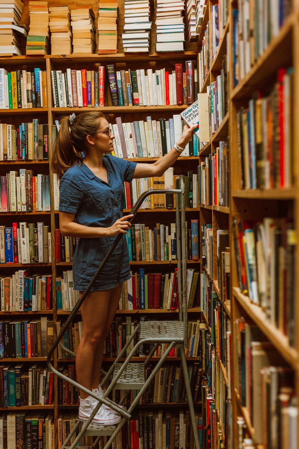 mulher pisa na escada enquanto segura livro