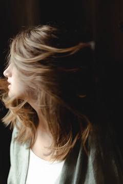 Healthy hair blowing gently in the wind, showing volume and movement.
