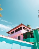 View of the building exterior with vibrant pastel walls under a sunny sky.