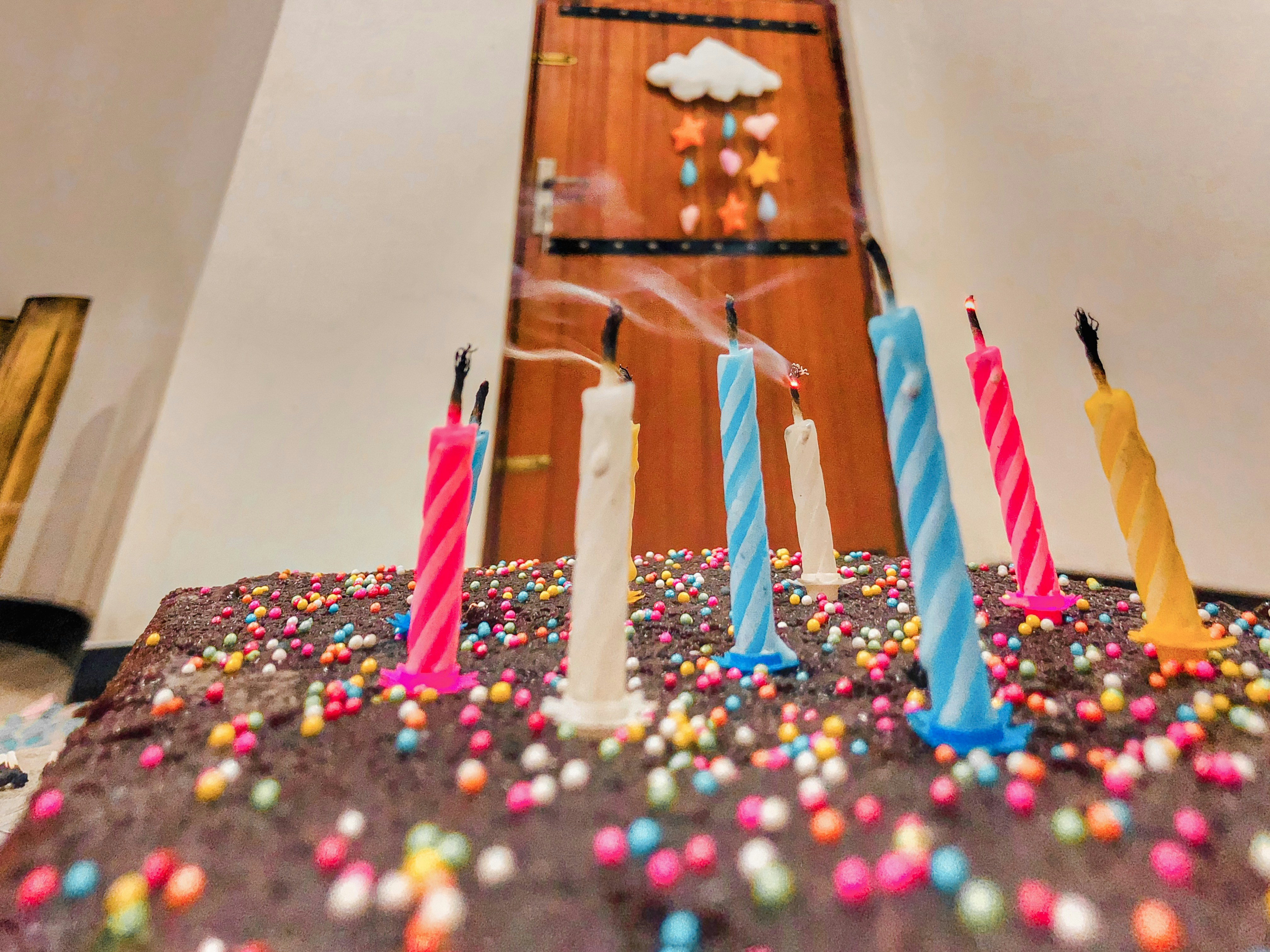 Chocolate drip birthday cake with rainbow sprinkles and gold number candles