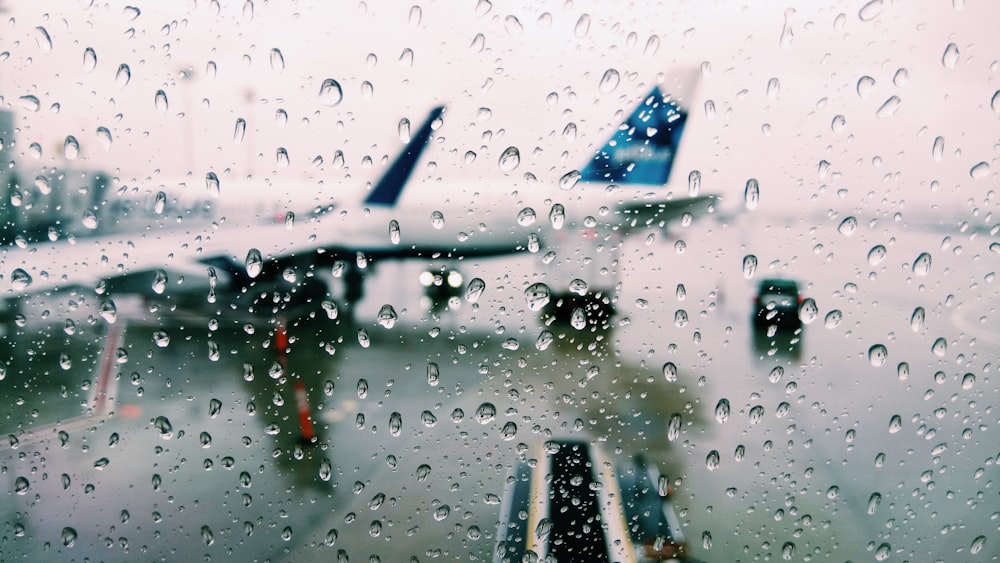 water drops viewing white and blue airplane