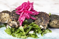 A colorful falafel rice bowl topped with crispy falafel balls and drizzled with creamy tahini.