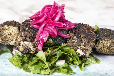 A vibrant display of falafel balls nestled among fresh greens and pickles.