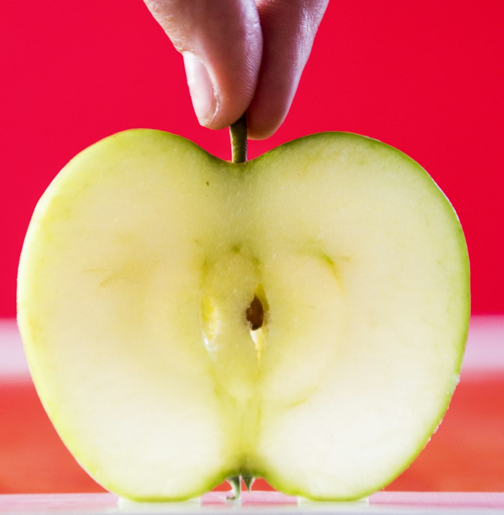 personne tenant une photo de pomme verte