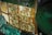 A close-up view of electronic circuit boards with detailed patterns and components. The intricate design includes various pathways, connections, and textured surfaces. Metallic bolts and nuts are visible, securing the pieces together, while the board exhibits a mix of green, brown, and cream colors.