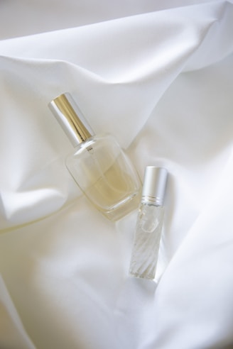 two bottles on white textile