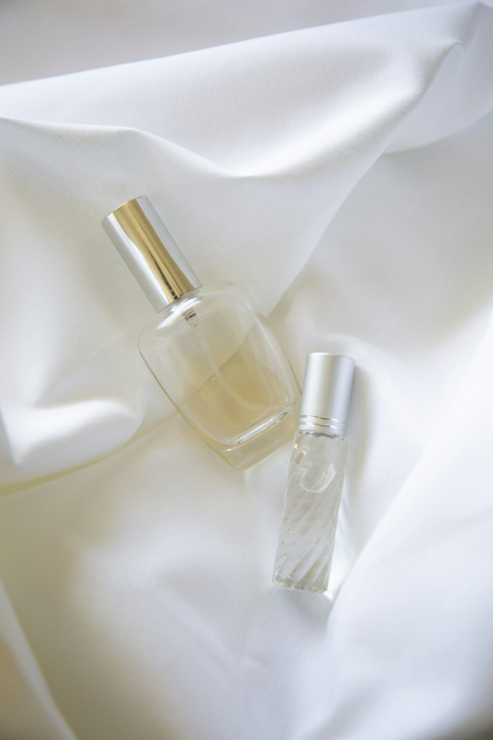 two bottles on white textile