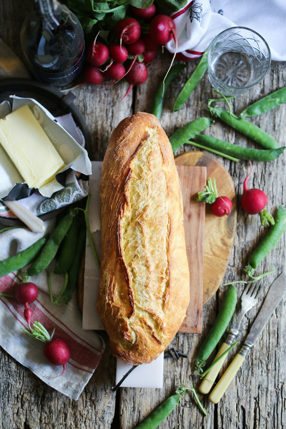 bread on cutting board surrounded with vegetables