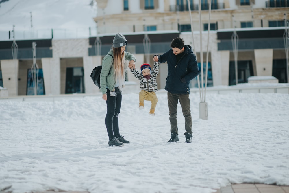 a woman and two children playing in the snow