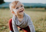 selective focus photo of baby crawling on grass