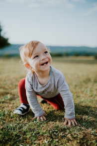 selective focus photo of baby crawling on grass