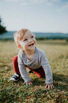 selective focus photo of baby crawling on grass