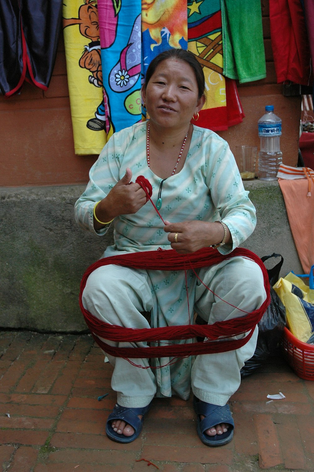 une femme assise par terre avec un panier devant elle