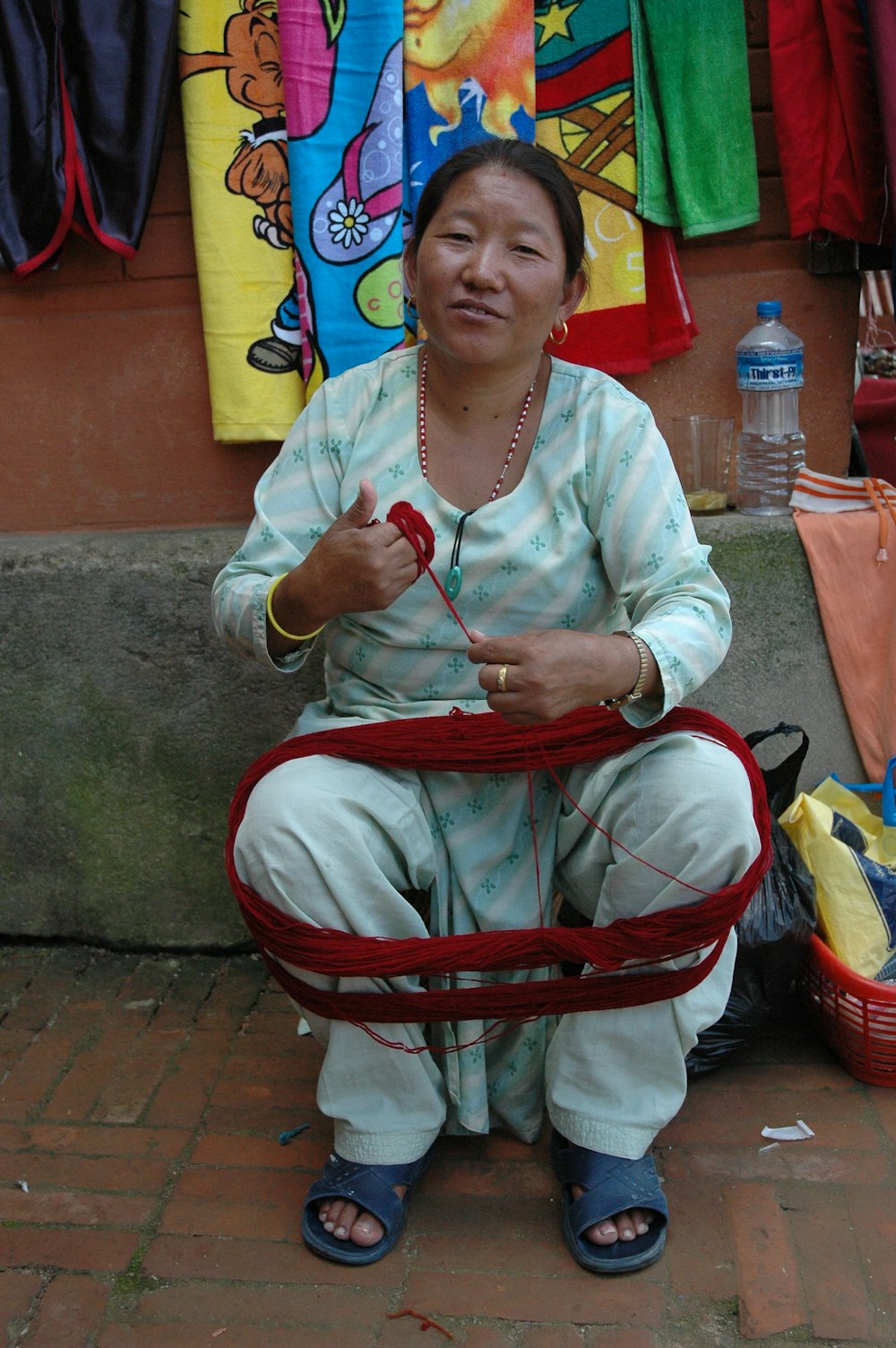 a woman sitting on the ground with a basket in front of her