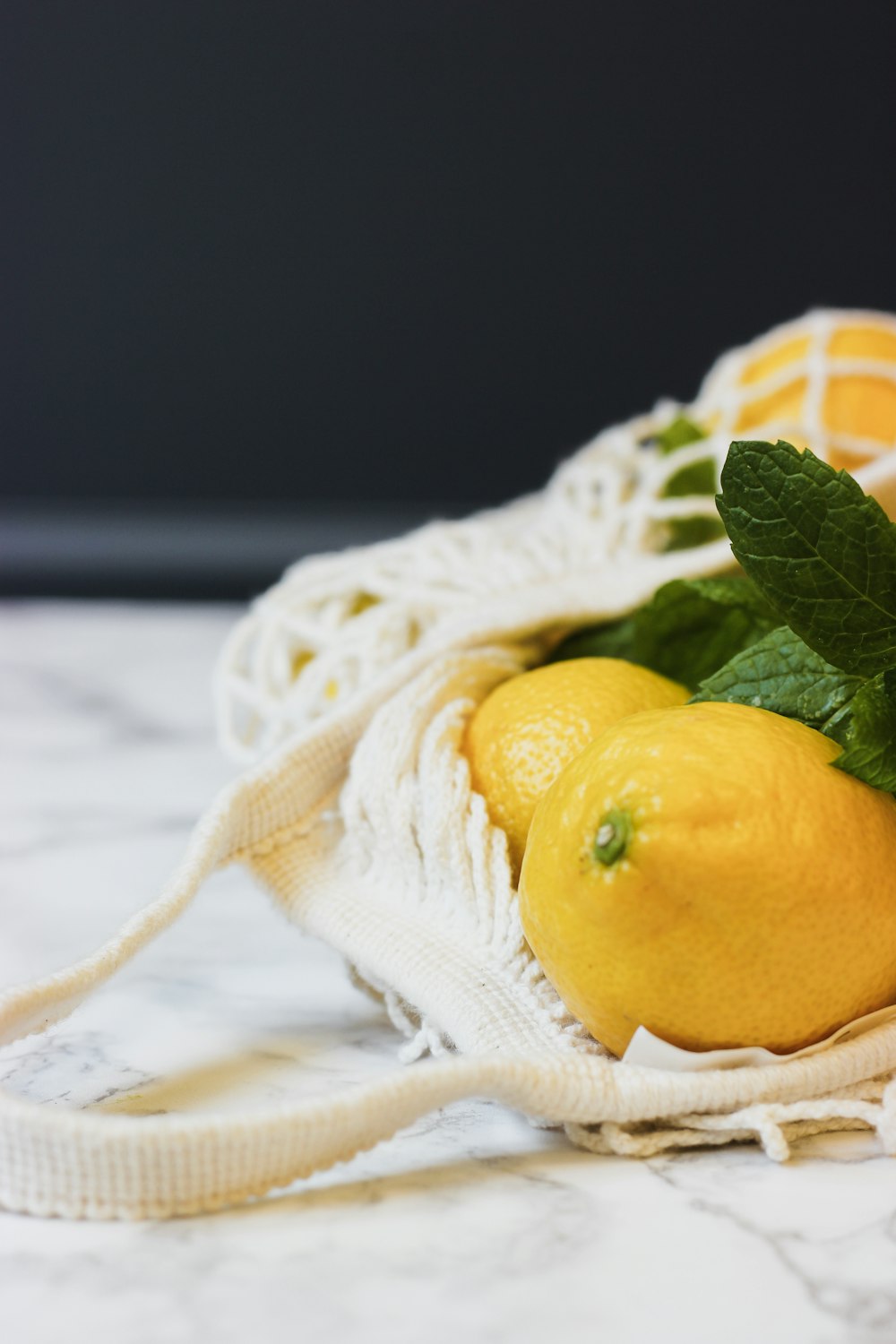 dos limones y un limón en una bolsa de tela