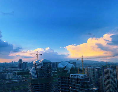 A vibrant aerial view of Navi Mumbai's skyline with cranes and new buildings under construction.