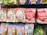 Various packaged snacks and candies are displayed on a store shelf. The packages feature colorful designs with images of fruits, beverages, and cartoon characters. The text on the packaging is in Japanese, with prominent depictions of strawberries, matcha, and milk tea.