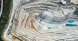 an aerial view of a quarry with a blue pool