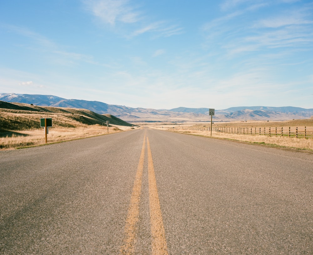 Carretera de hormigón negro y naranja bajo el cielo blanco