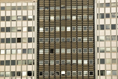 Symmetrical grid of windows on a contemporary building with subtle gray tones.