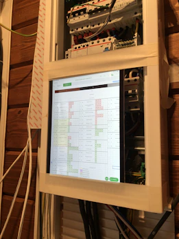 Technician installing a security system panel inside a home.