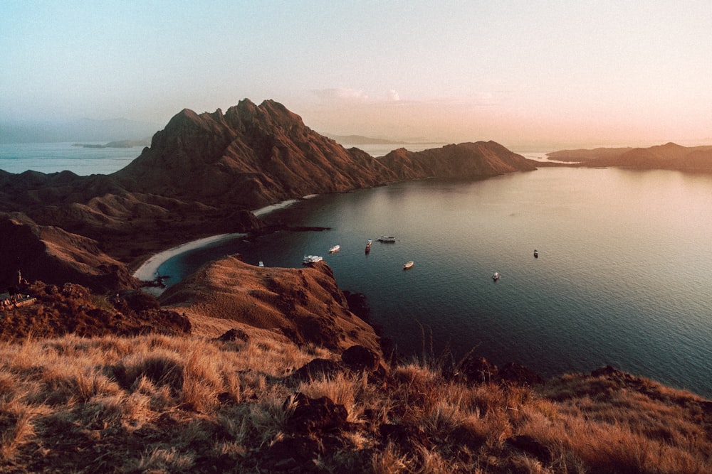 brown mountain beside body of water at golden hour