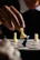 Friendly chess coach explaining a move to an attentive student at a table.