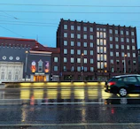 Evening scene of a mechanic finishing an inspection under soft street lighting, with Vienna’s cityscape in the background.