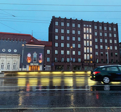 Evening scene of a mechanic finishing an inspection under soft street lighting, with Vienna’s cityscape in the background.