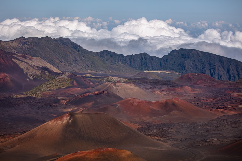 brown and green mountains under white clouds and blue sky during daytime