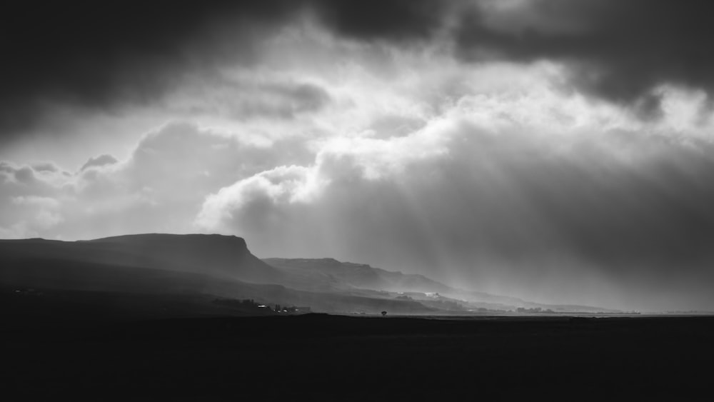 Una foto en blanco y negro de nubes sobre una montaña