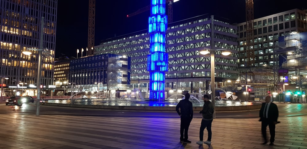 people standing near gray concrete buildings