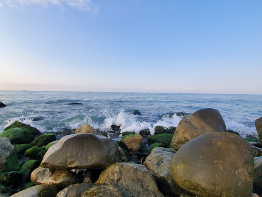 brown and green rock formation near body of water in Ramsar Iran