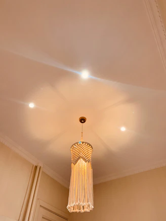 A cozy room softly lit by a bohemian beaded pendant light casting colorful shadows.