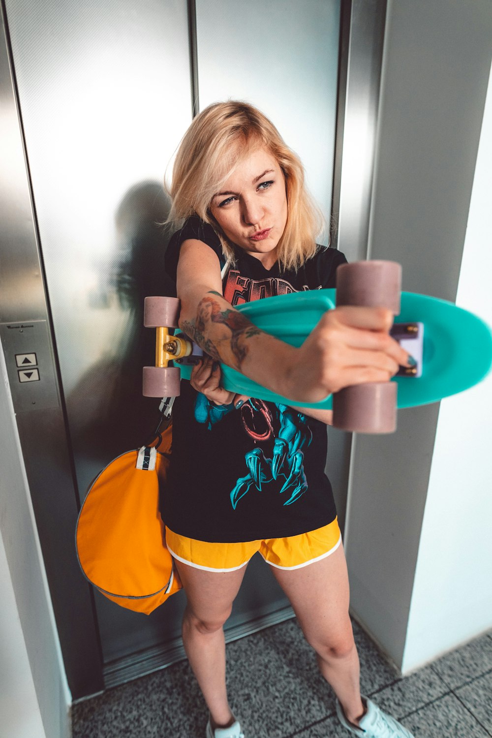 woman holding teal cruiser board