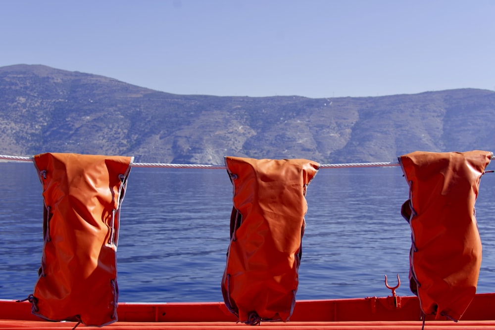 three red leather bags hanging on rope