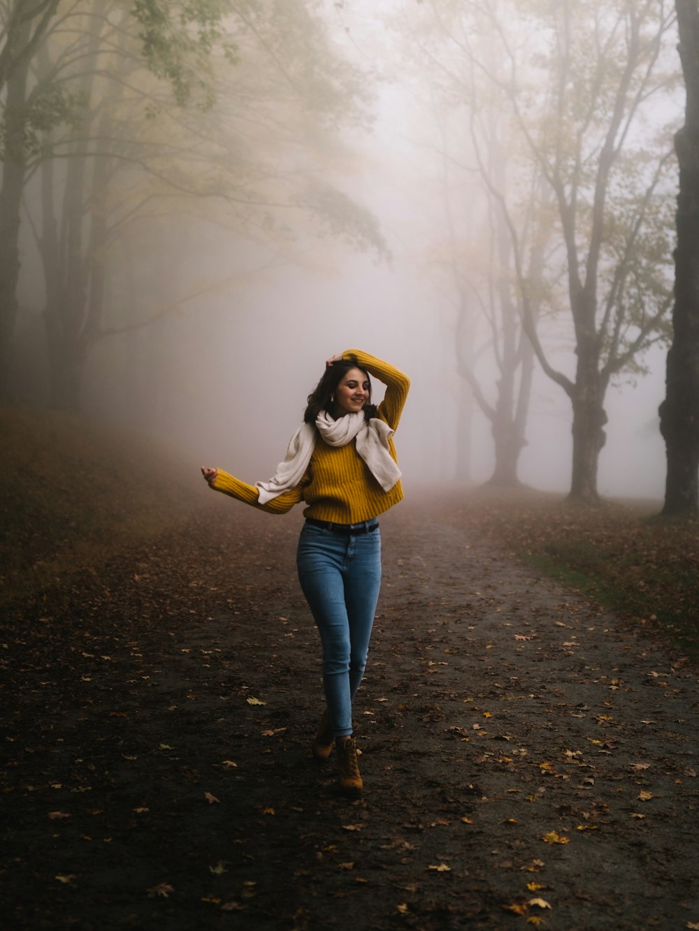 woman walking on road near trees during day