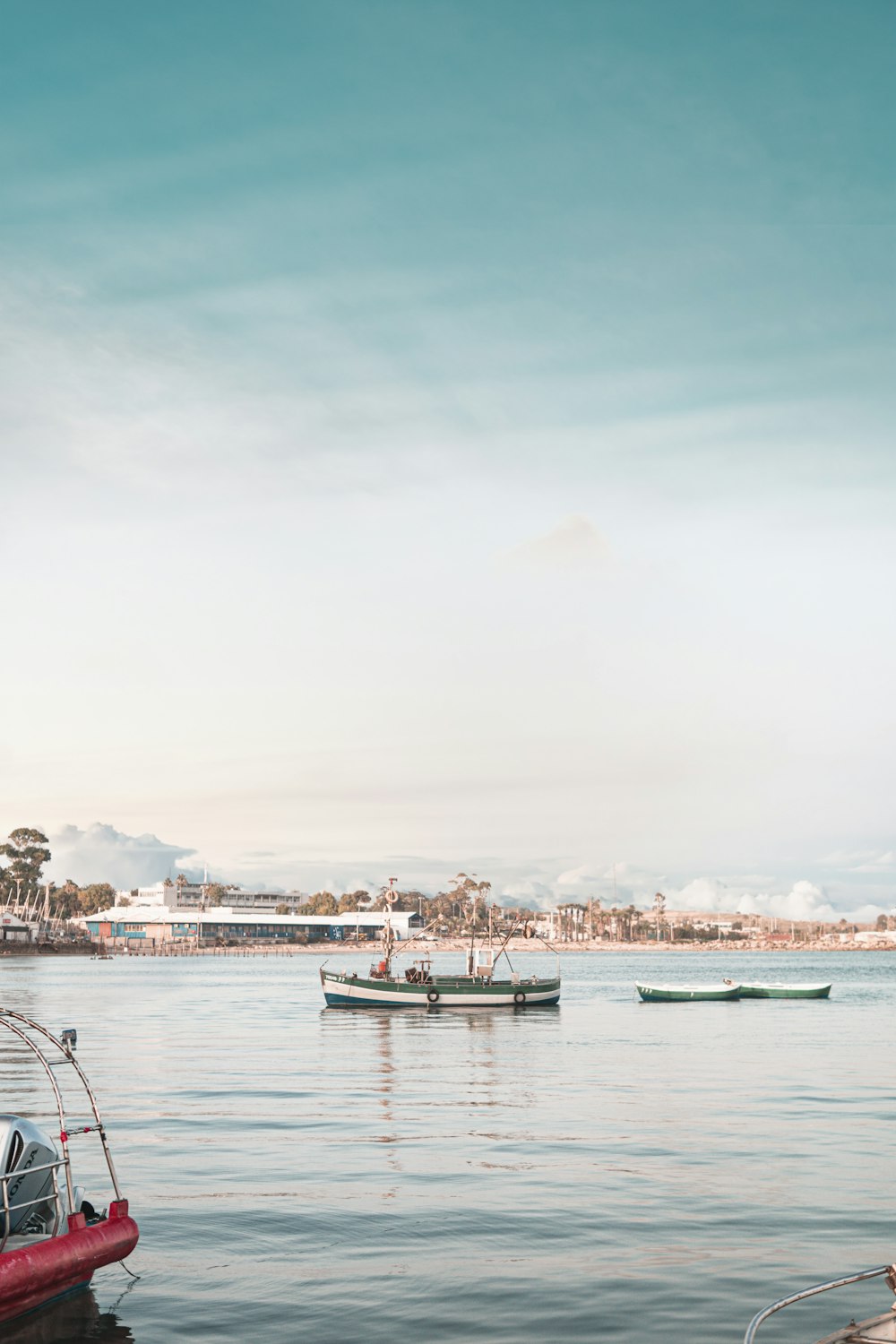 black and white boats on calm sea under clear blue sky